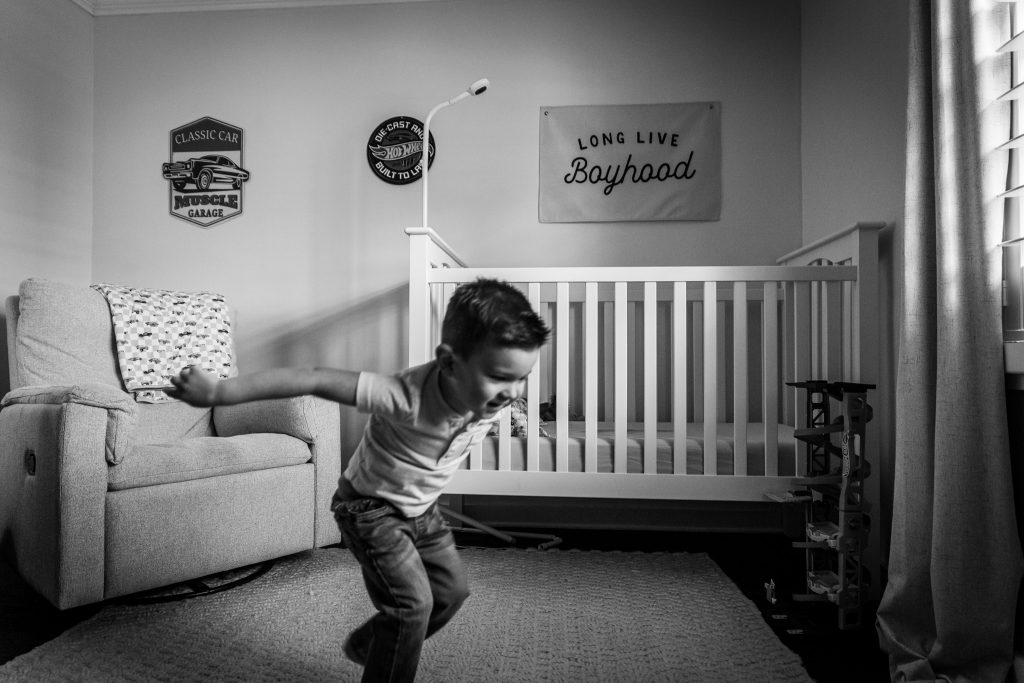 Young child playing and jumping in his bedroom