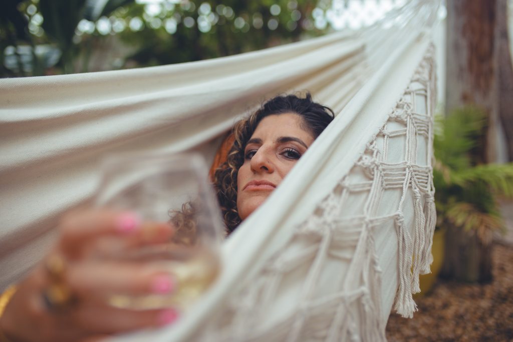 Mother having a glass of wine in a hammock