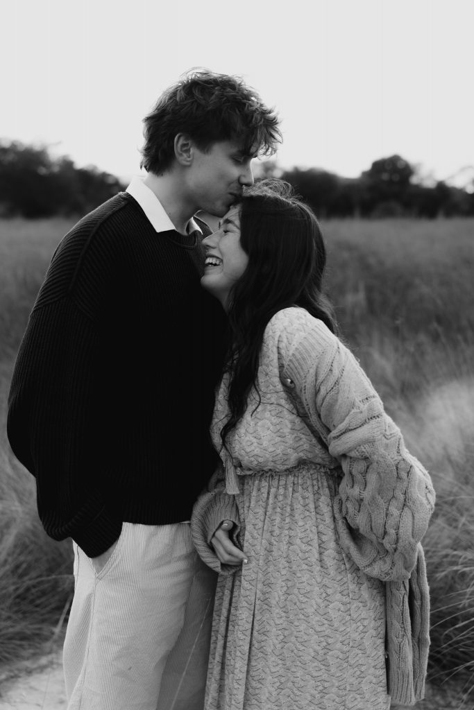 Young couple at a field as the sun is setting.