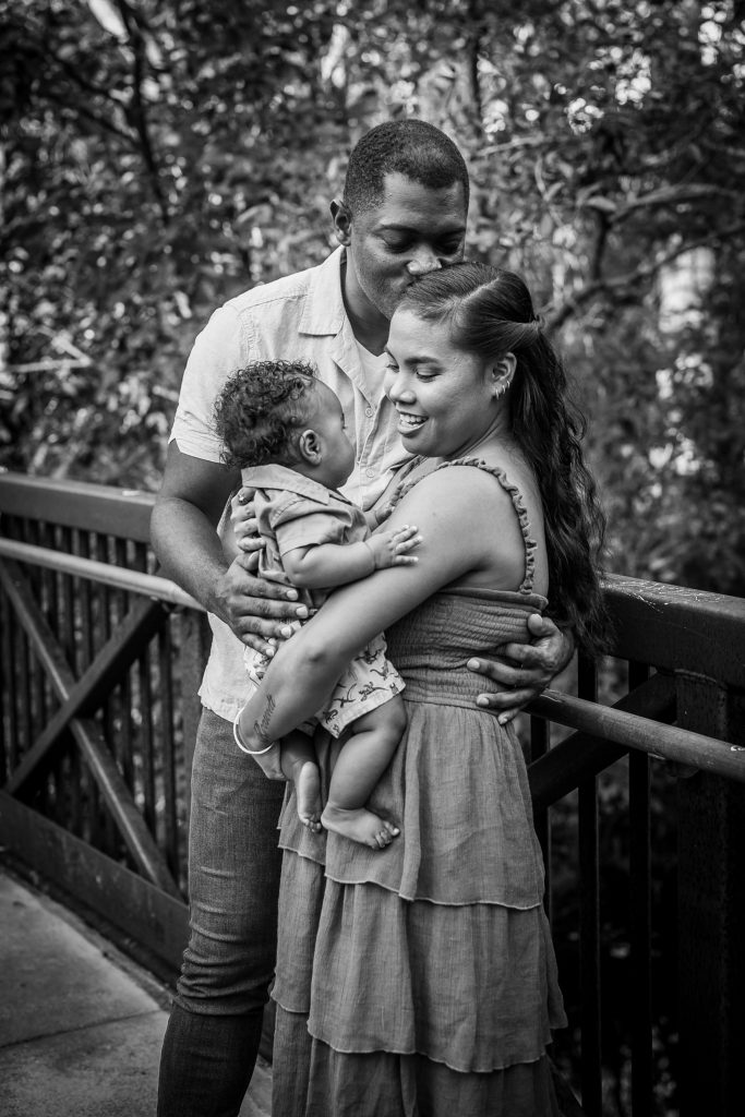 Family of 3 at the park on a bridge at a family session