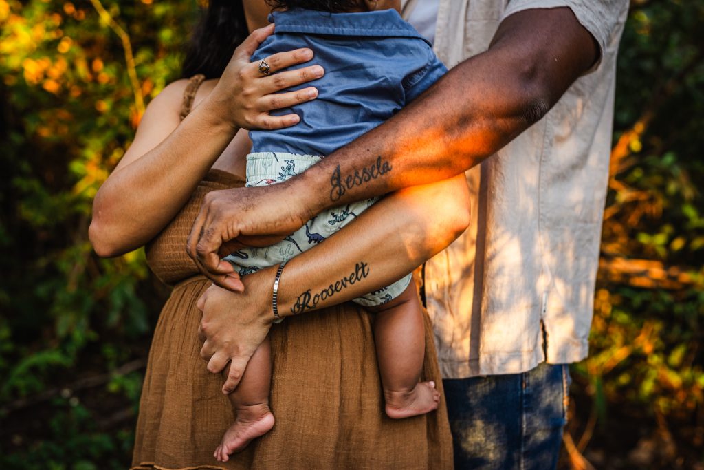 Mom, Dad and baby showing off their tattoos at a family session