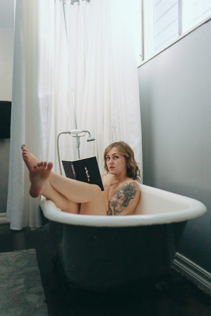 Mother reading a book in the bathtub