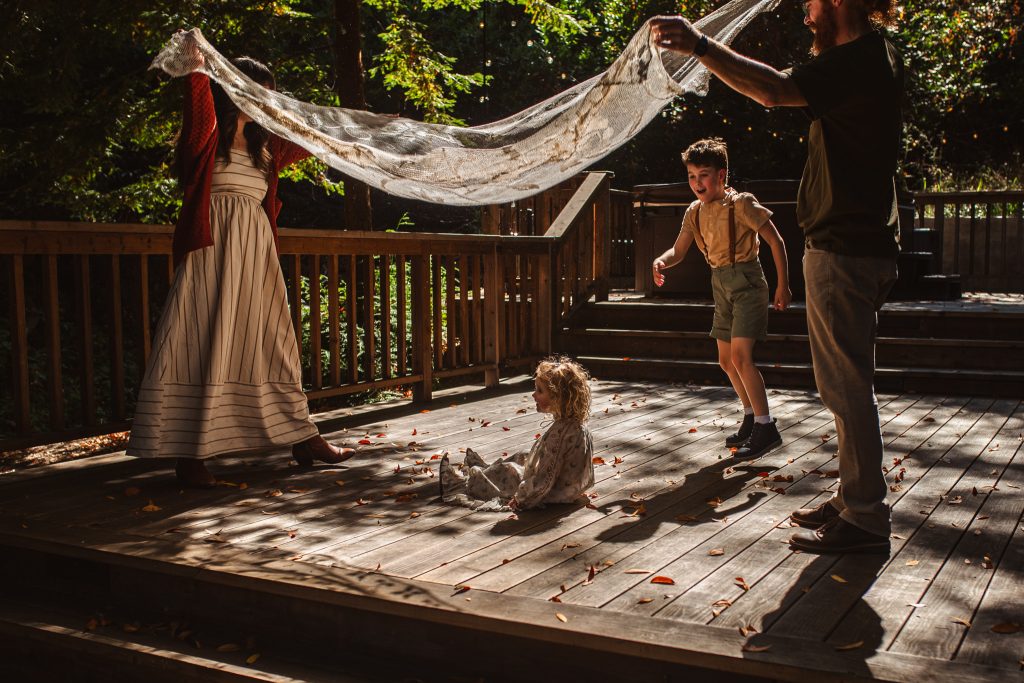 Family playing with a tablecloth